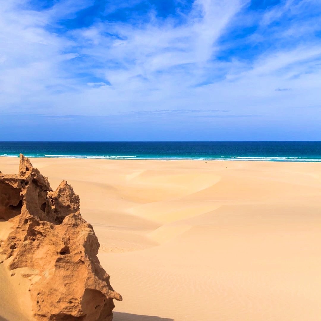 Duna di sabbia chiara, roccia scura e oceano a Boa Vista