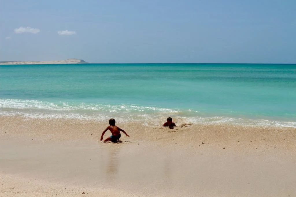 Bambini che giocano nel mare turchese di Boa Vista