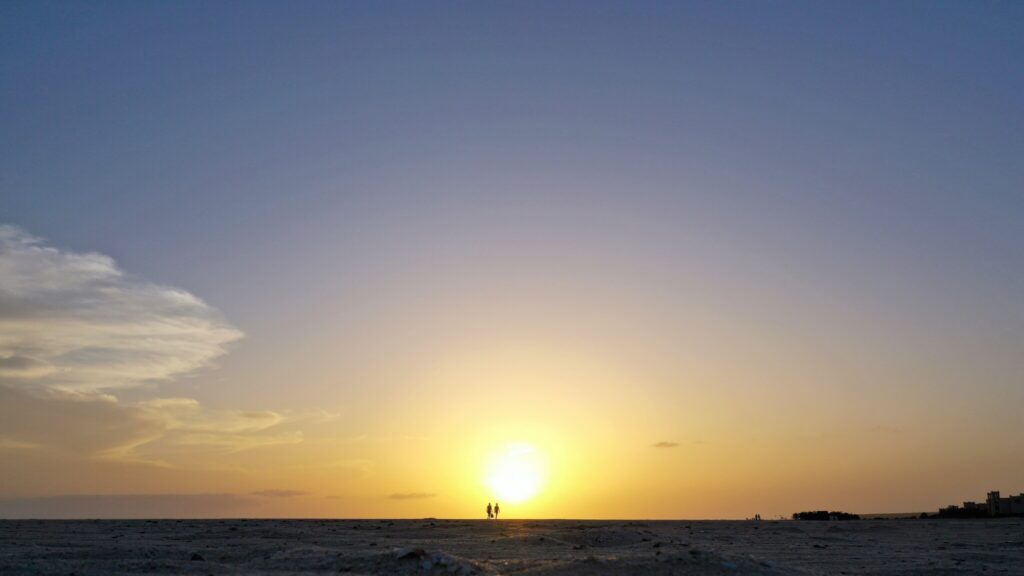 Due persone camminano sulla spiaggia di Boa Vista al tramonto