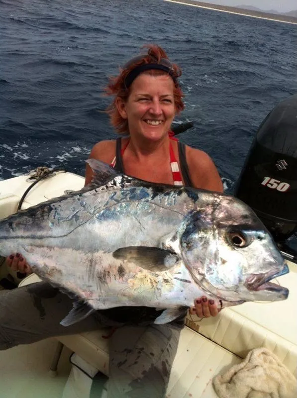 Pescatrice sorridente con un carangide argentato