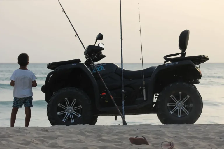 Bambino accanto a un quad con le canne al tramonto
