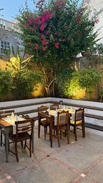 Tavoli nel cortile di Sodade sotto la bouganville