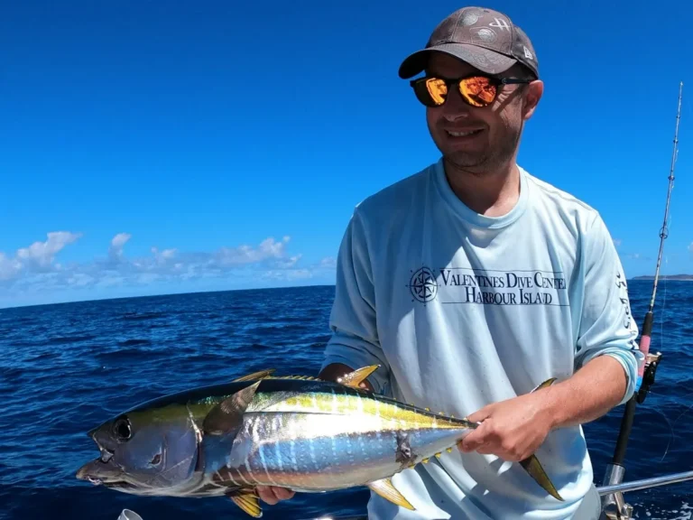 Pescatore sorridente con un tonno pinna gialla