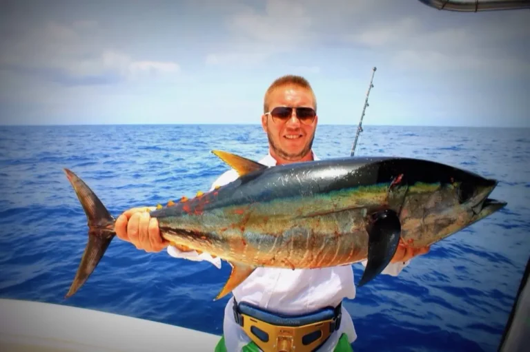 Pescatore con un grande tonno sulla barca