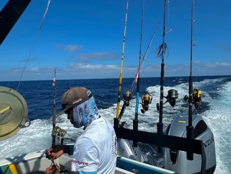 Pescatore a poppa con le canne da traina in pesca